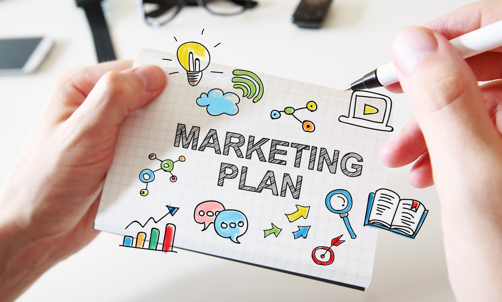 Mans hand drawing Marketing Plan concept on white notebook. Marketing organic products for dropshipping