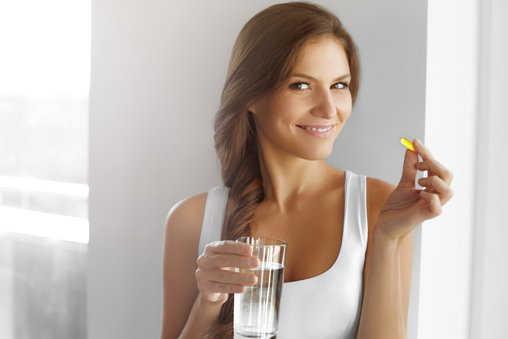 organic health and wellness products for dropshipping. Smiling woman taking a supplement.
